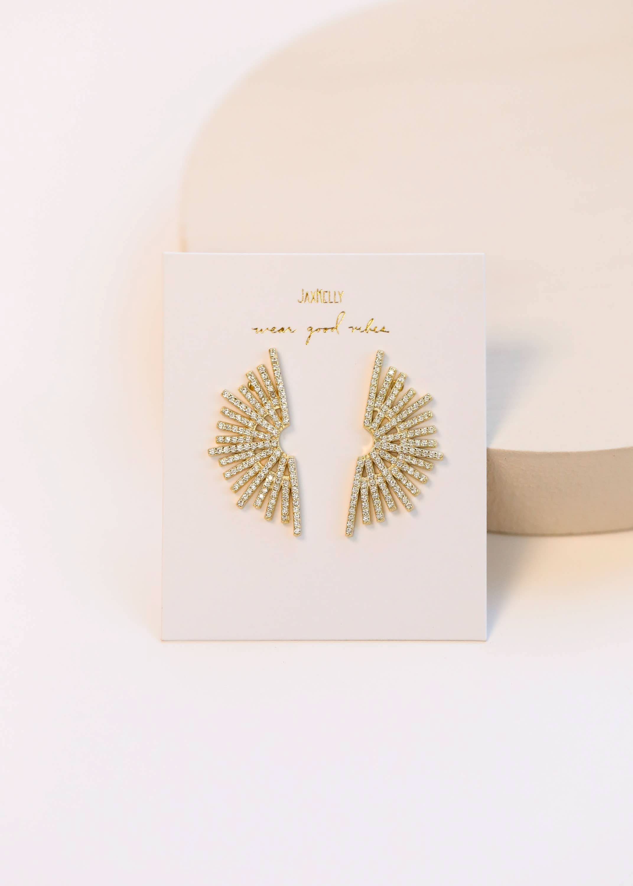 Celestial Sunburst Gold earrings on a white card with a beige background