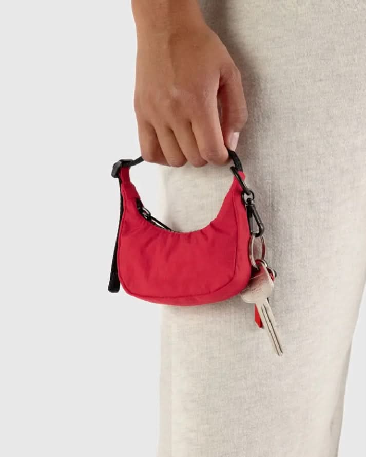 Red keychain pouch held by a hand with a neutral background