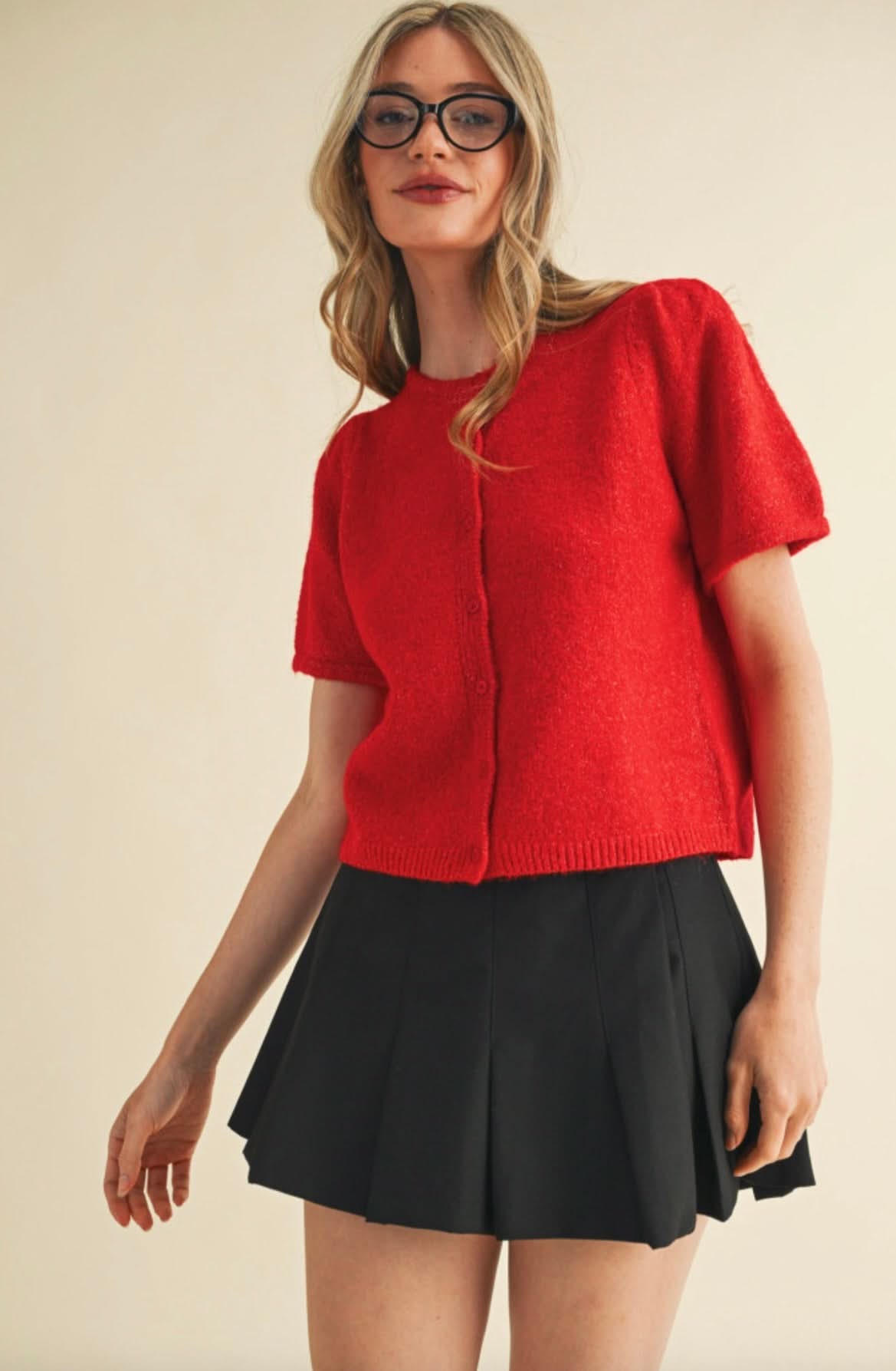 Woman wearing red, fuzzy, short sleeved, button up cardigan 