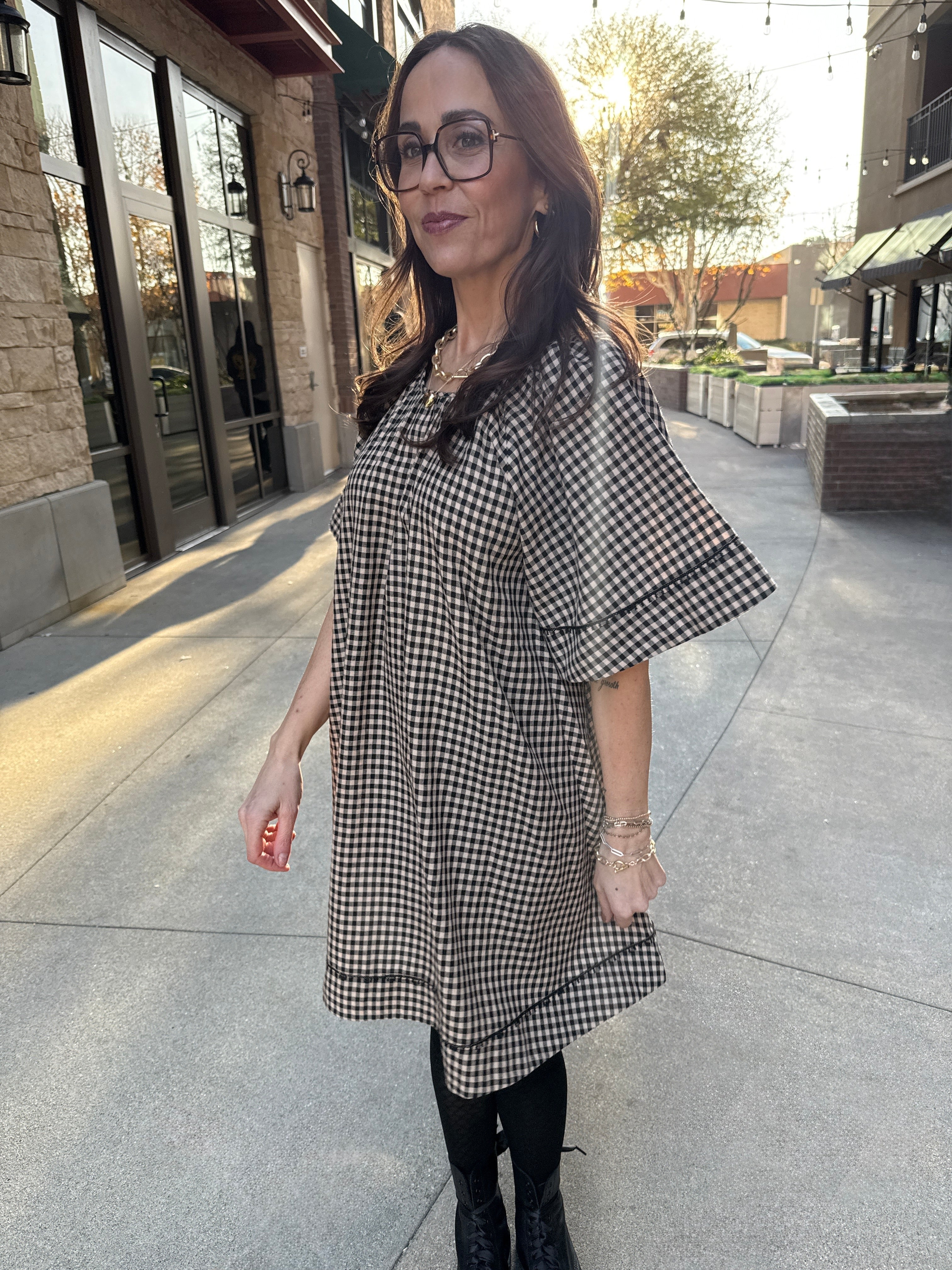 Model wearing Vintage style babydoll dress black and tan gingham pattern with lace details 