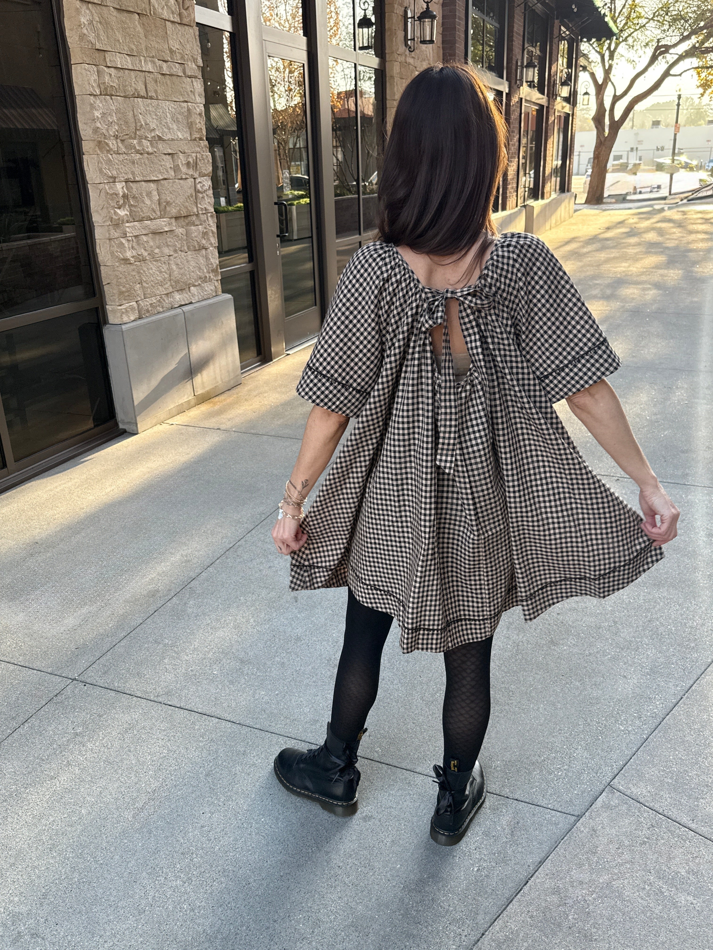 Model wearing Vintage style babydoll dress black and tan gingham pattern with lace details 