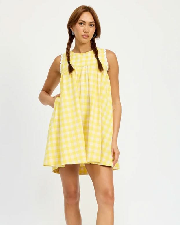 Woman wearing a yellow polka dot dress on a white background