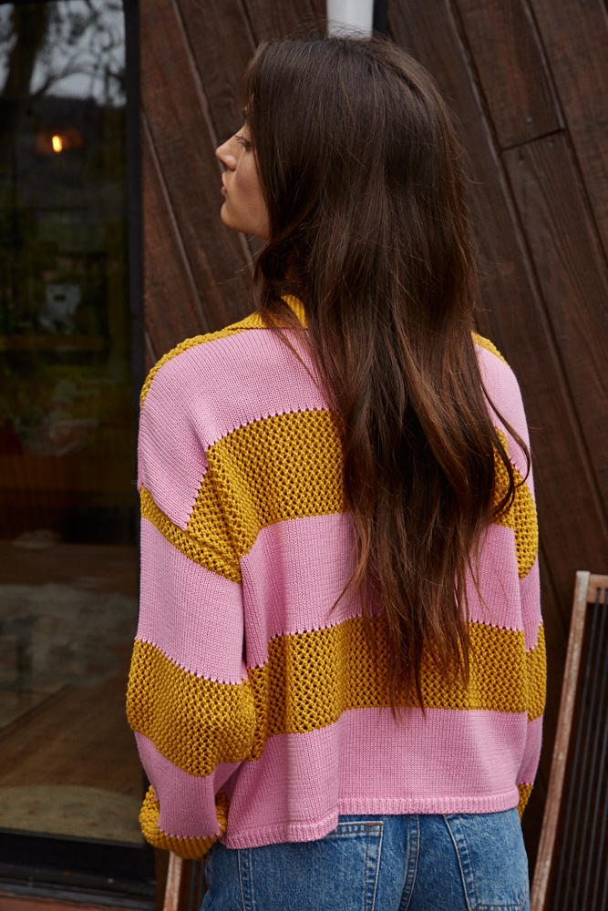 Woman wearing a pink and yellow striped sweater 