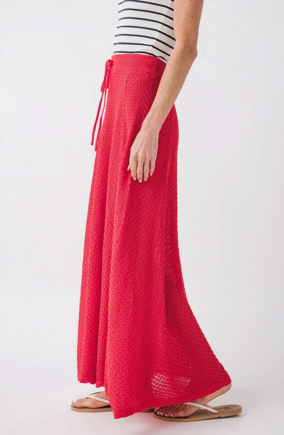 Woman wearing knit red skirt with diamond geometrical pattern and front tie 