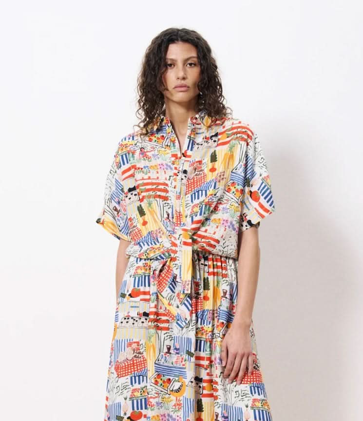 Woman wearing a colorful patterned dress on a white background