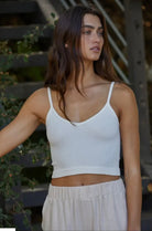 Woman wearing distressed, white, ribbed, spaghetti strap Brami tank top