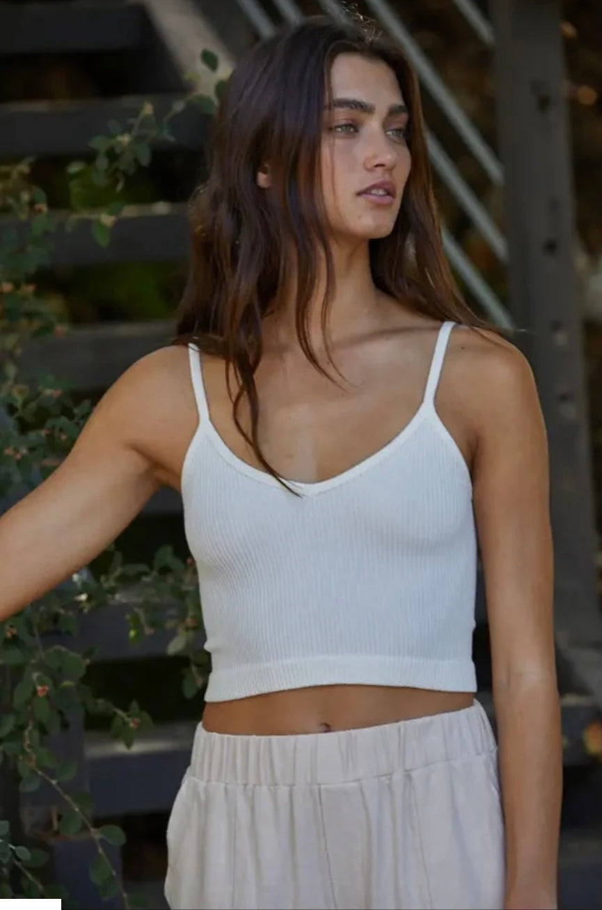 Woman wearing distressed, white, ribbed, spaghetti strap Brami tank top