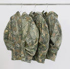Three Vintage camo real tree cotton pullover hoodie sweatshirts hanging on hangers 