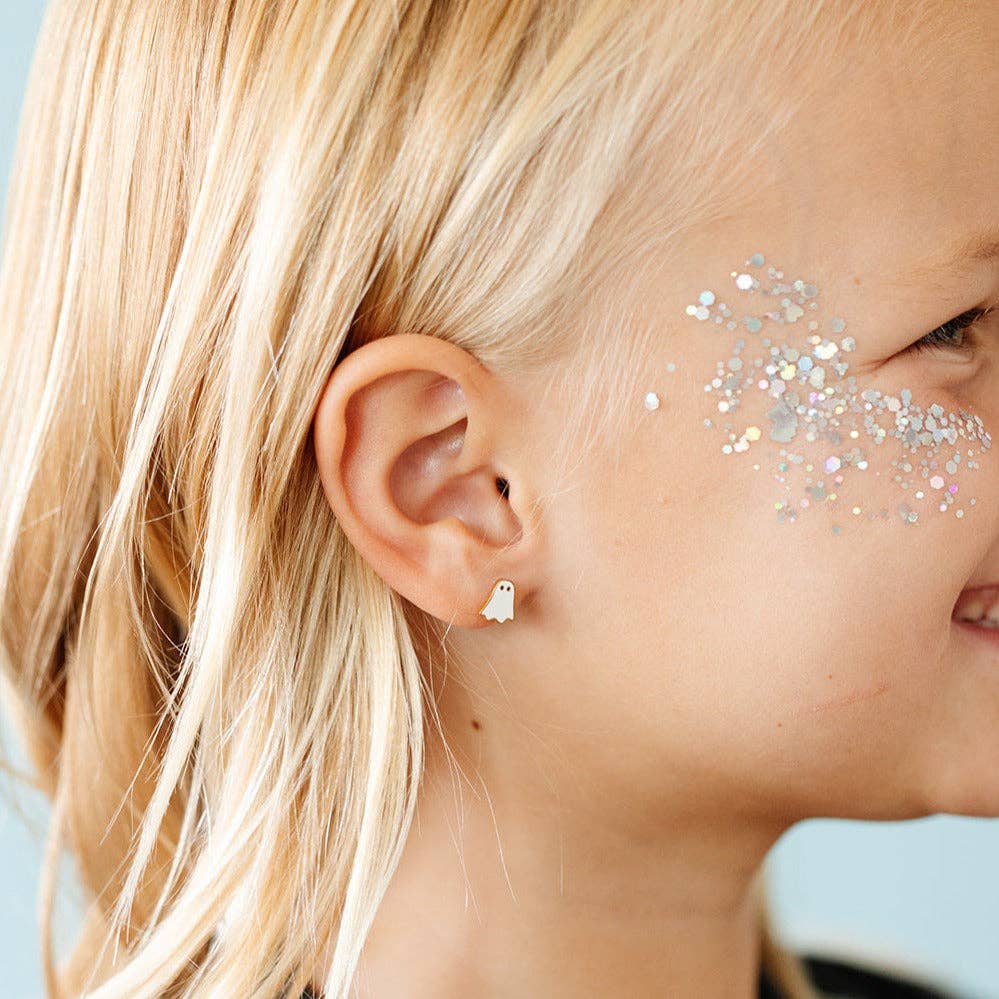 Close-up of a person wearing a ghost-shaped earring with glitter on their face.