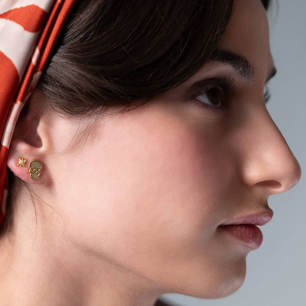 Close-up of a woman wearing gold skull earrings
