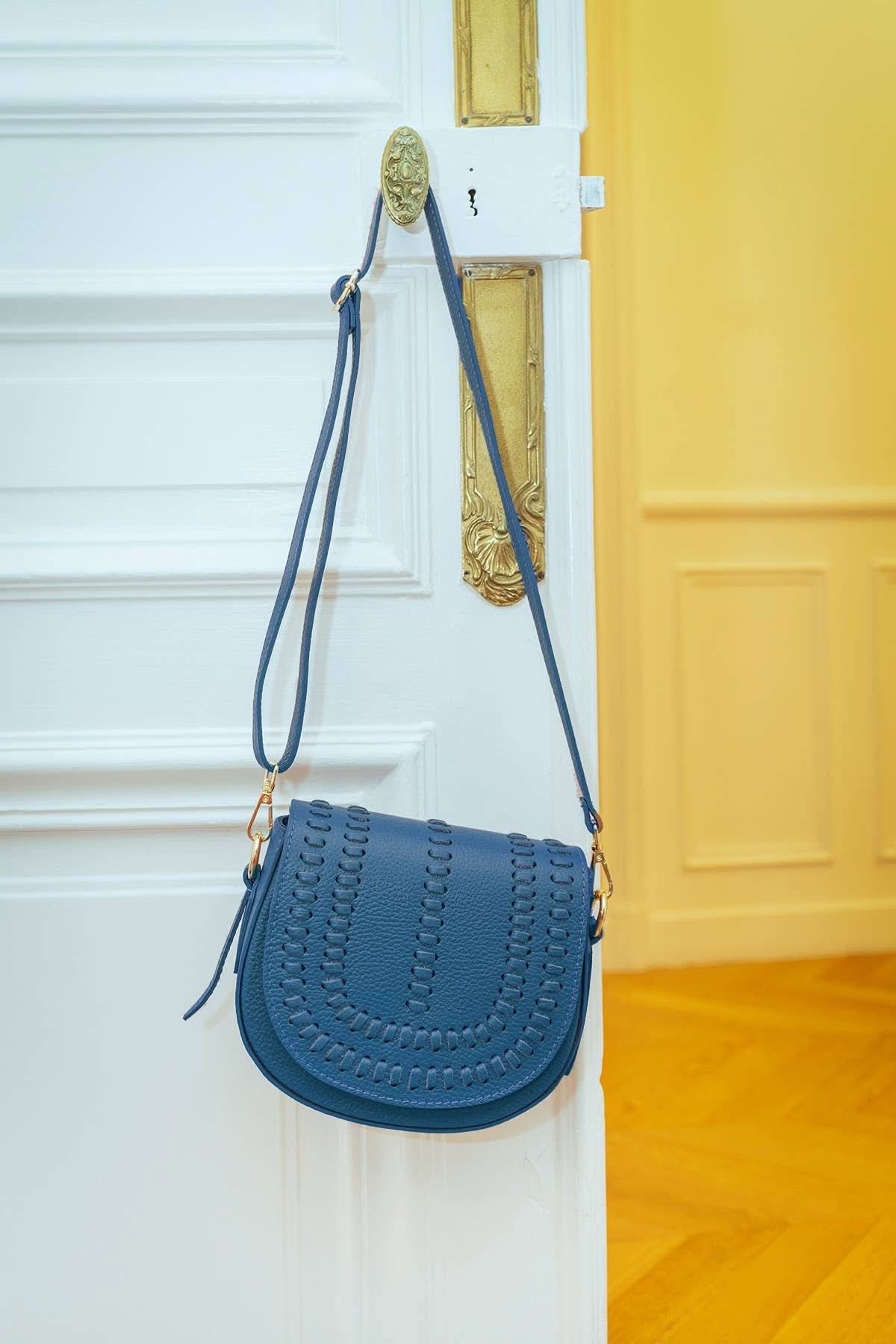 Oil blue colored leather crossbody bag with magnetic front clap and leather woven geometric design and gold Metal details 