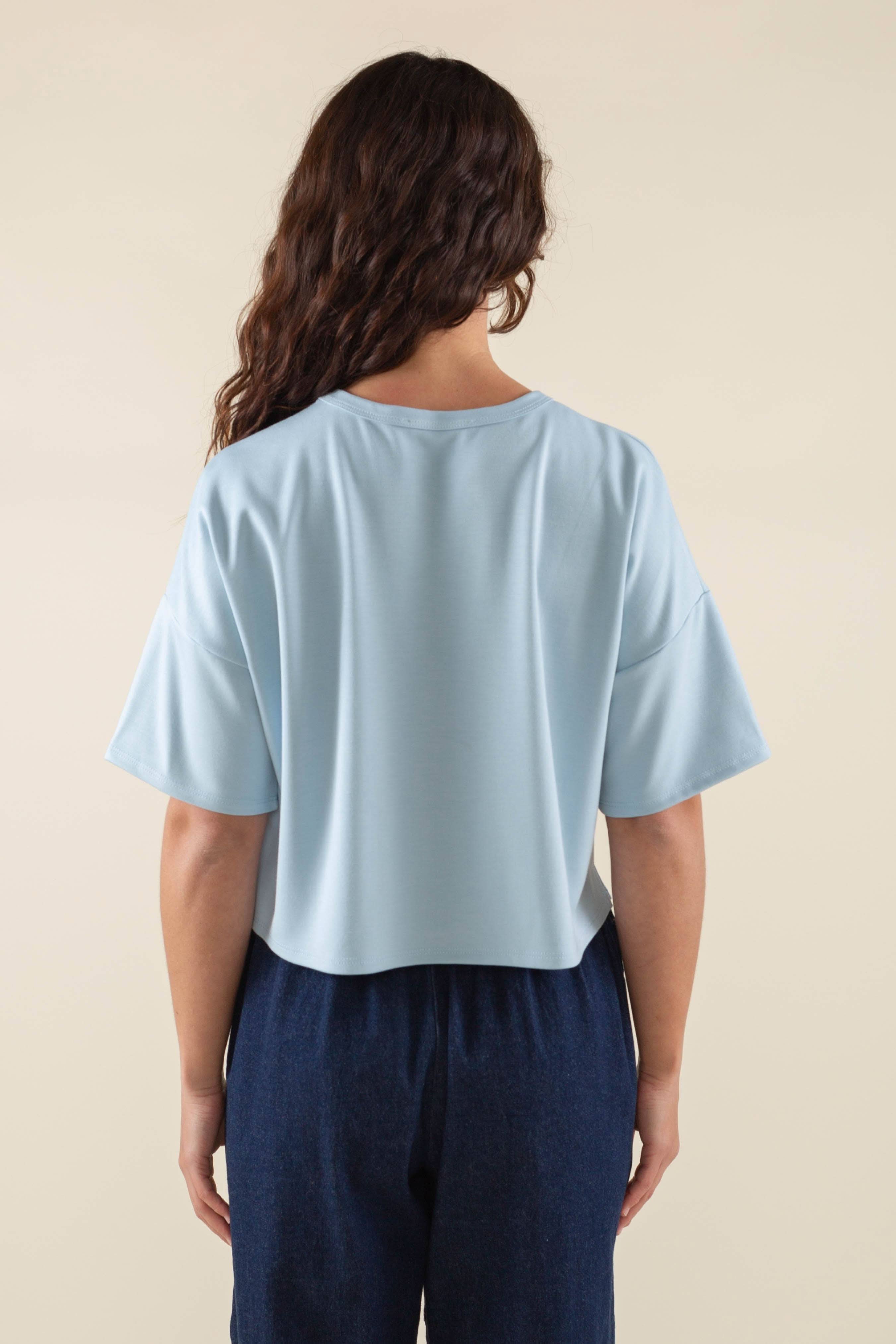 Woman wearing light sky blue, short sleeve, jersey, cropped t-shirt and blue jeans 