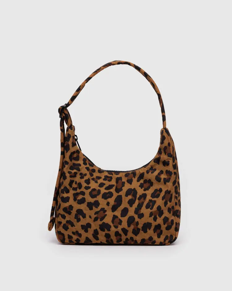 Small over the shoulder leopard purse behind a white background. 