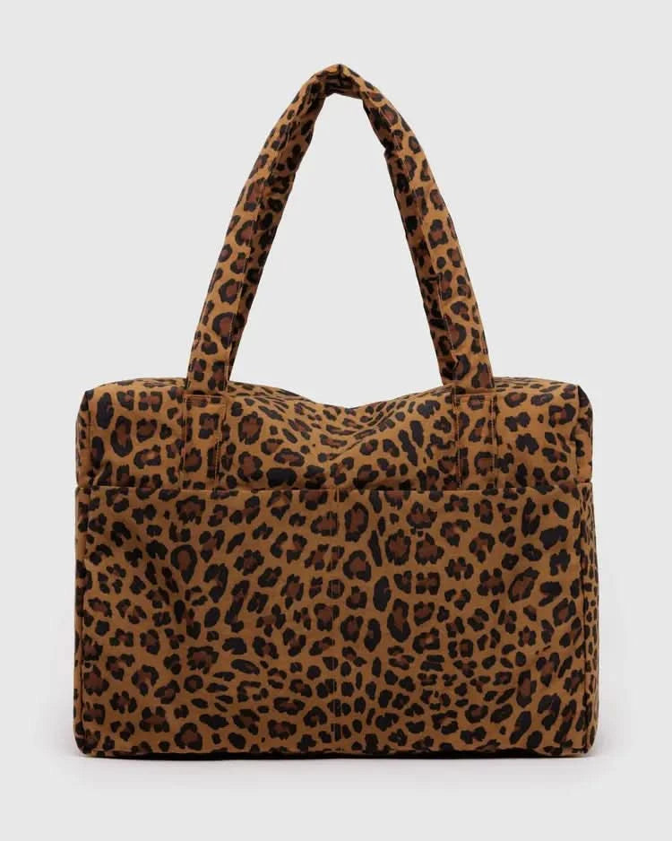 Large leopard carry-on tote bag behind a white background. 