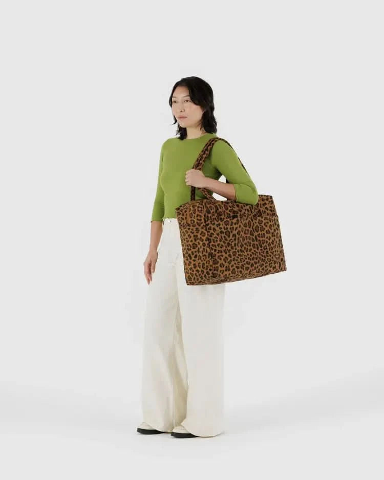 Women wearing green shirt in front of white background with leopard print large over the shoulder tote bag 