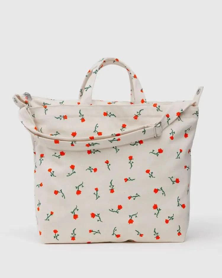 Cream white tote bag with two handle options with embroidered red and green floral designs 