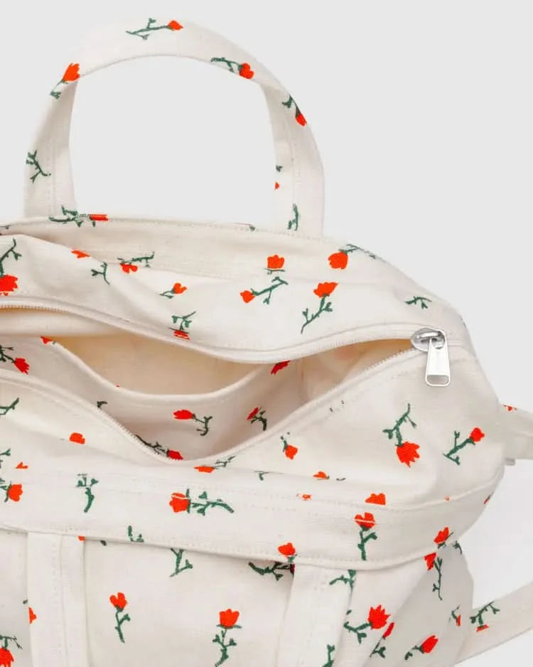 Zipper details of Cream white tote bag with two handle options with embroidered red and green floral designs 