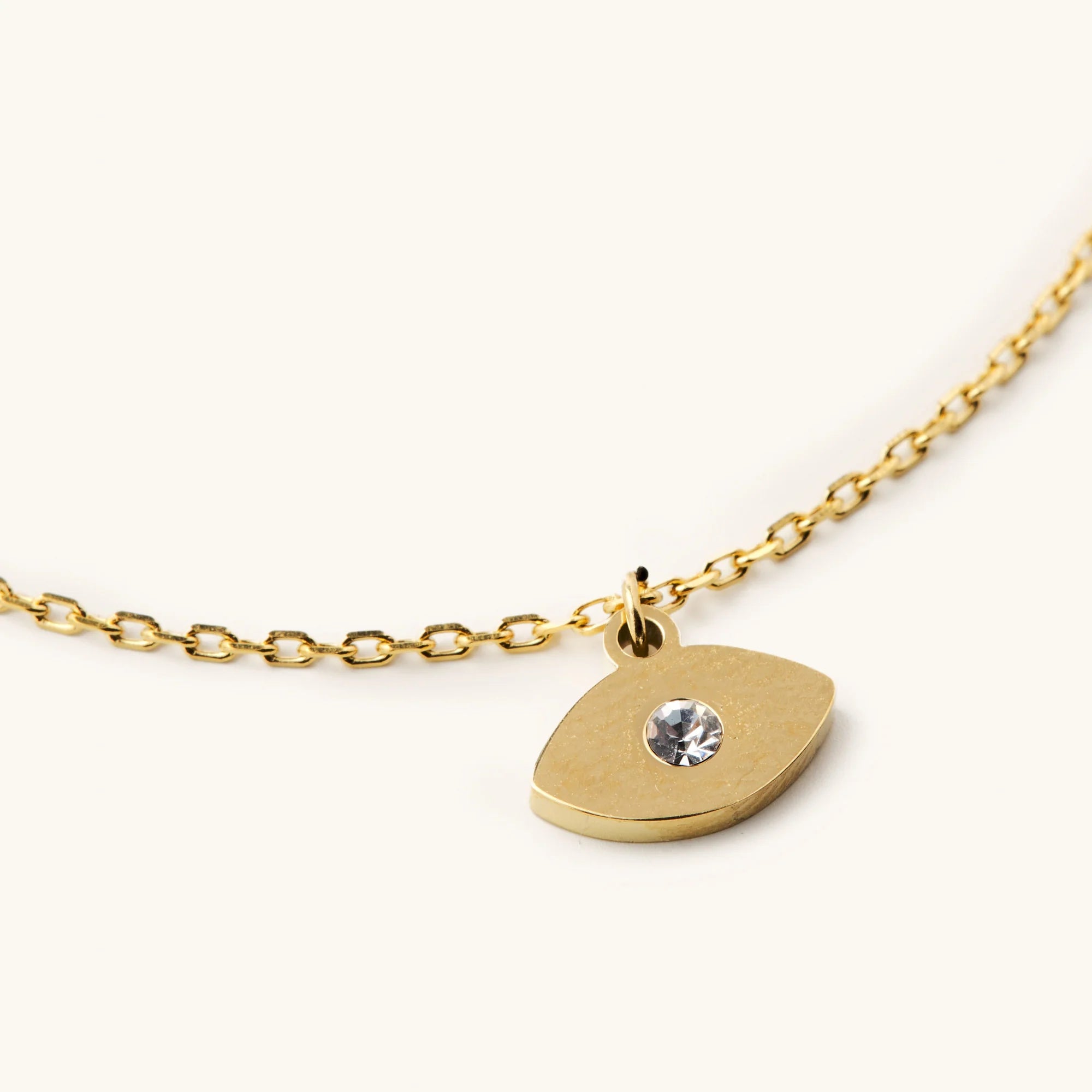 Gold necklace with a eye pendant on a white background