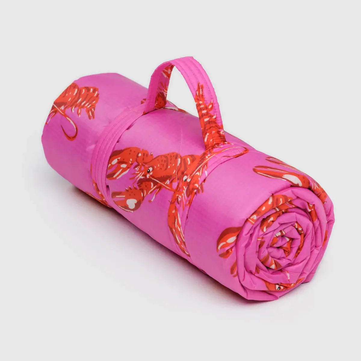 Pink rolled-up mat with red floral pattern on a light gray background