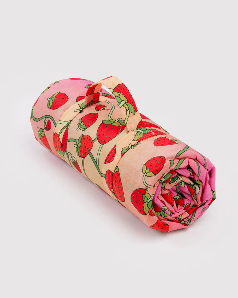 Rolled-up fabric with strawberry pattern on a light gray background