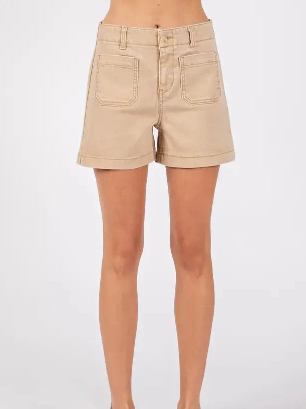 Beige shorts worn by a person on a white background