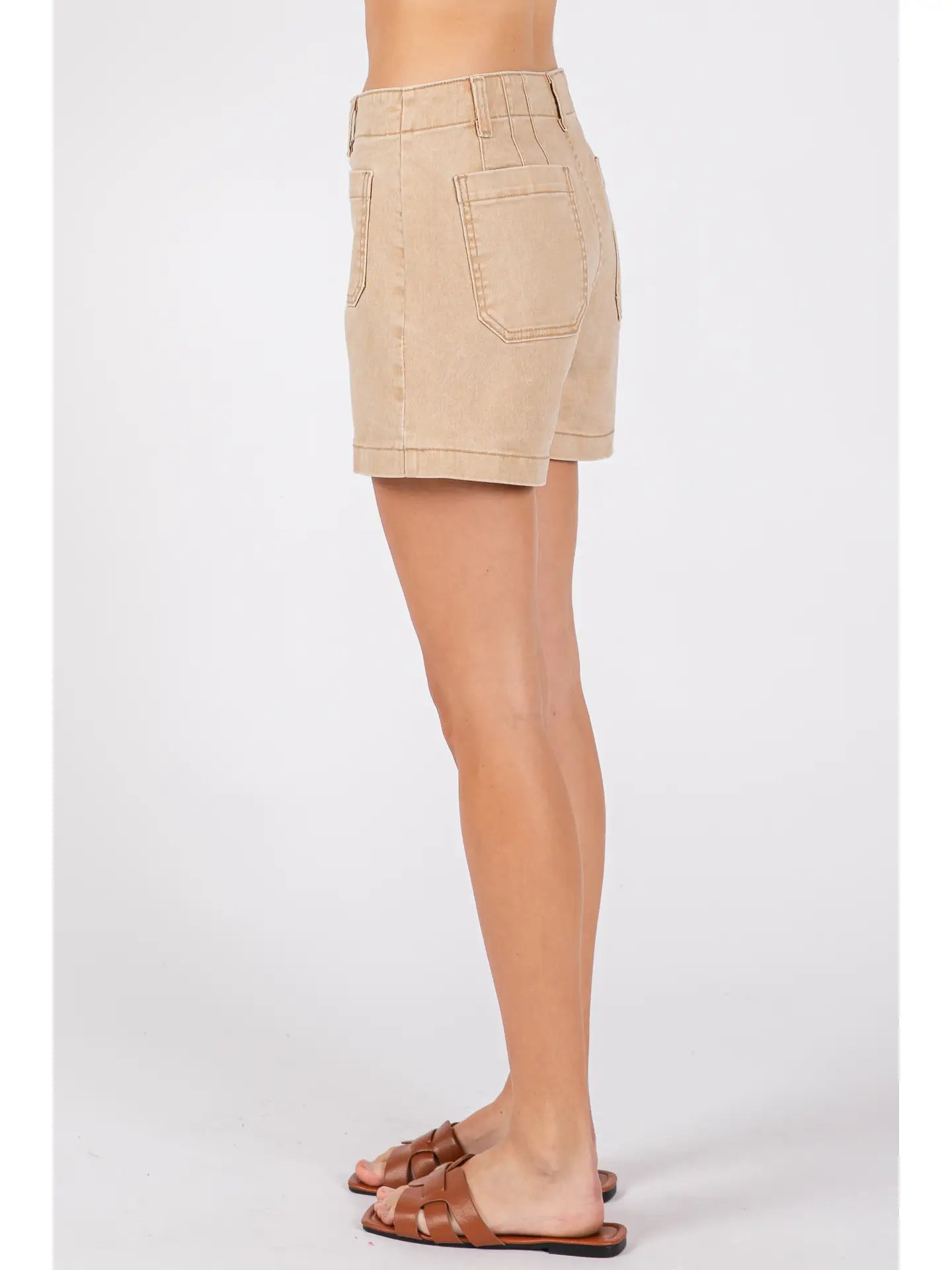 Beige shorts worn by a person on a white background