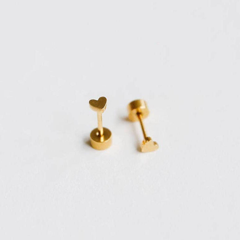 Pair of gold heart-shaped earrings on a light gray background