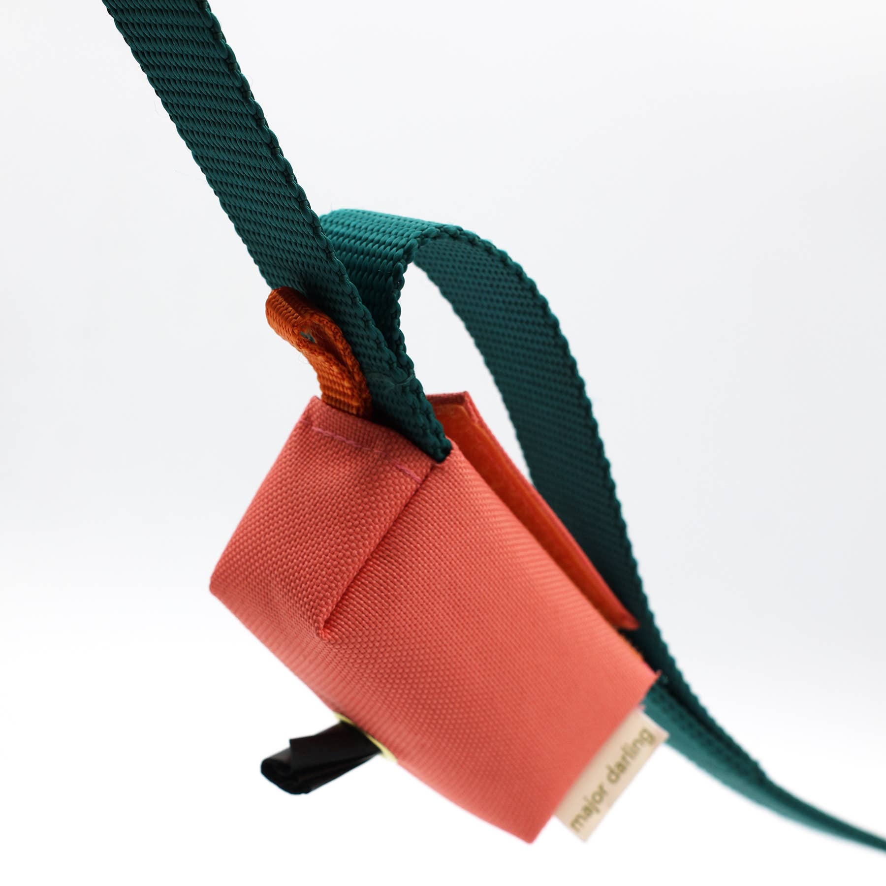 Orange poop bag with a blue strap on a white background