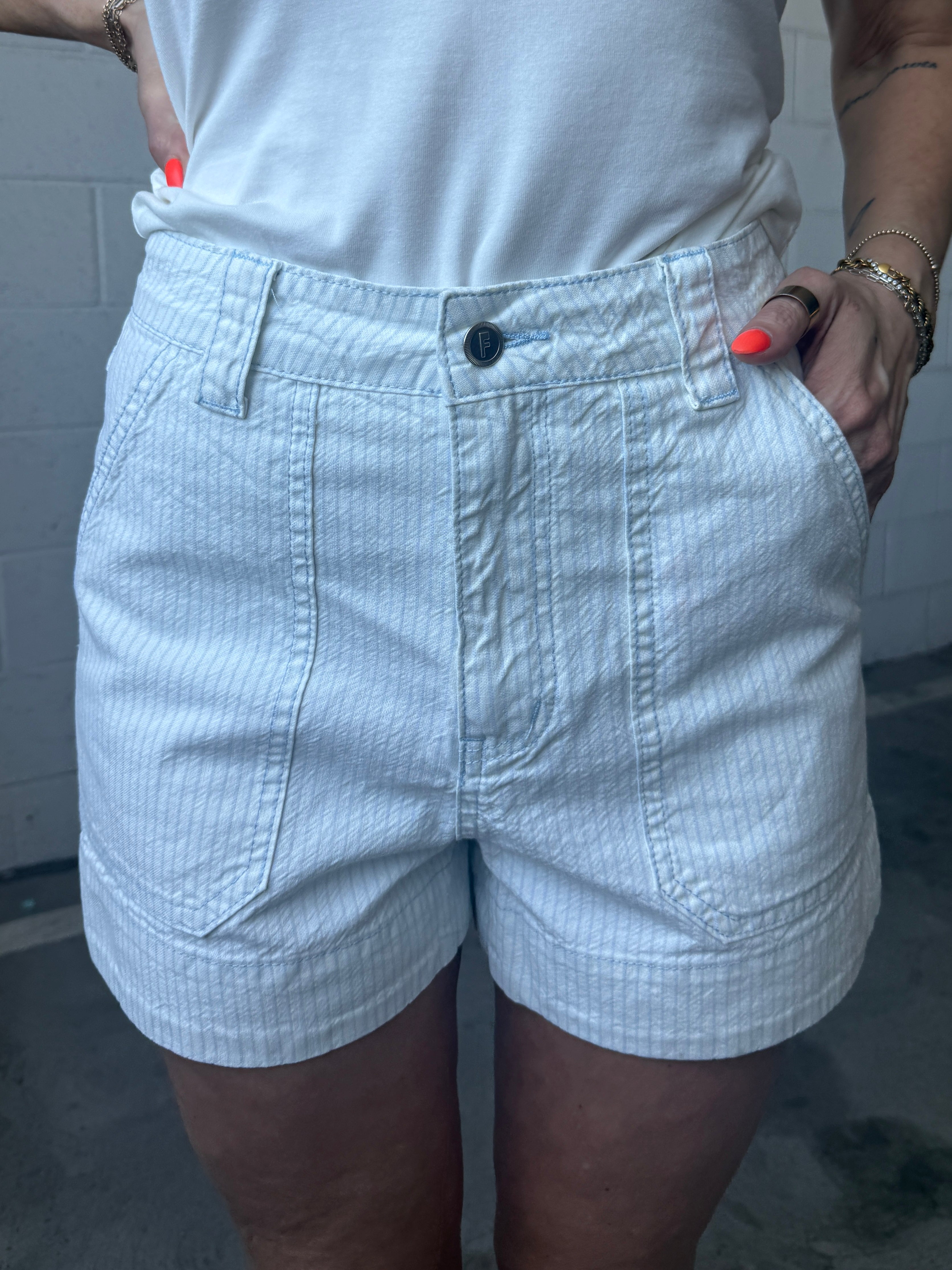 Person wearing light-colored shorts with a neutral background