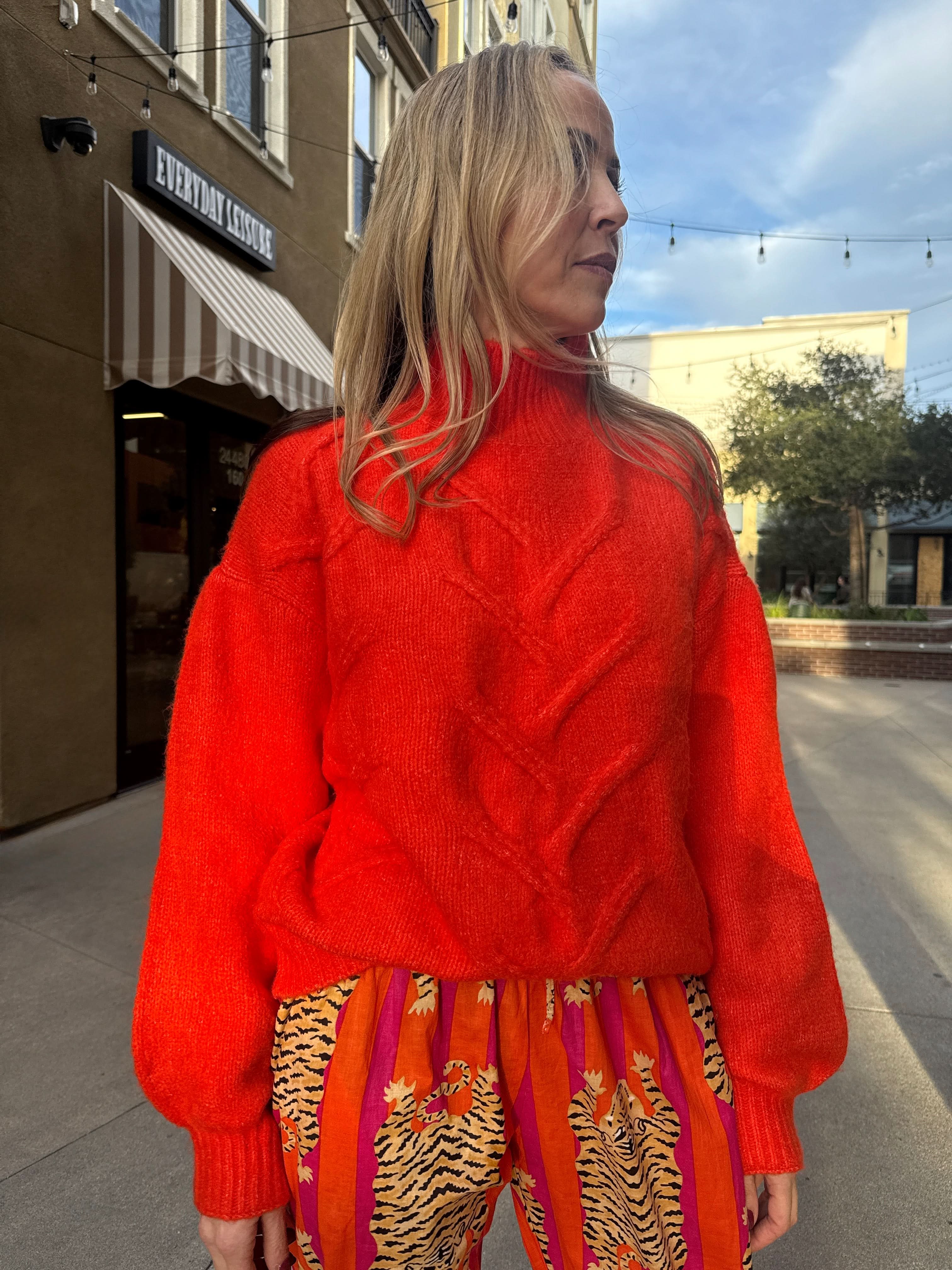 woman wearing Bright Orange, fisherman, knit, high neck, sweater
