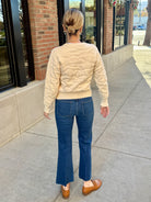 cream pearl detail winter sweater and blue jeans