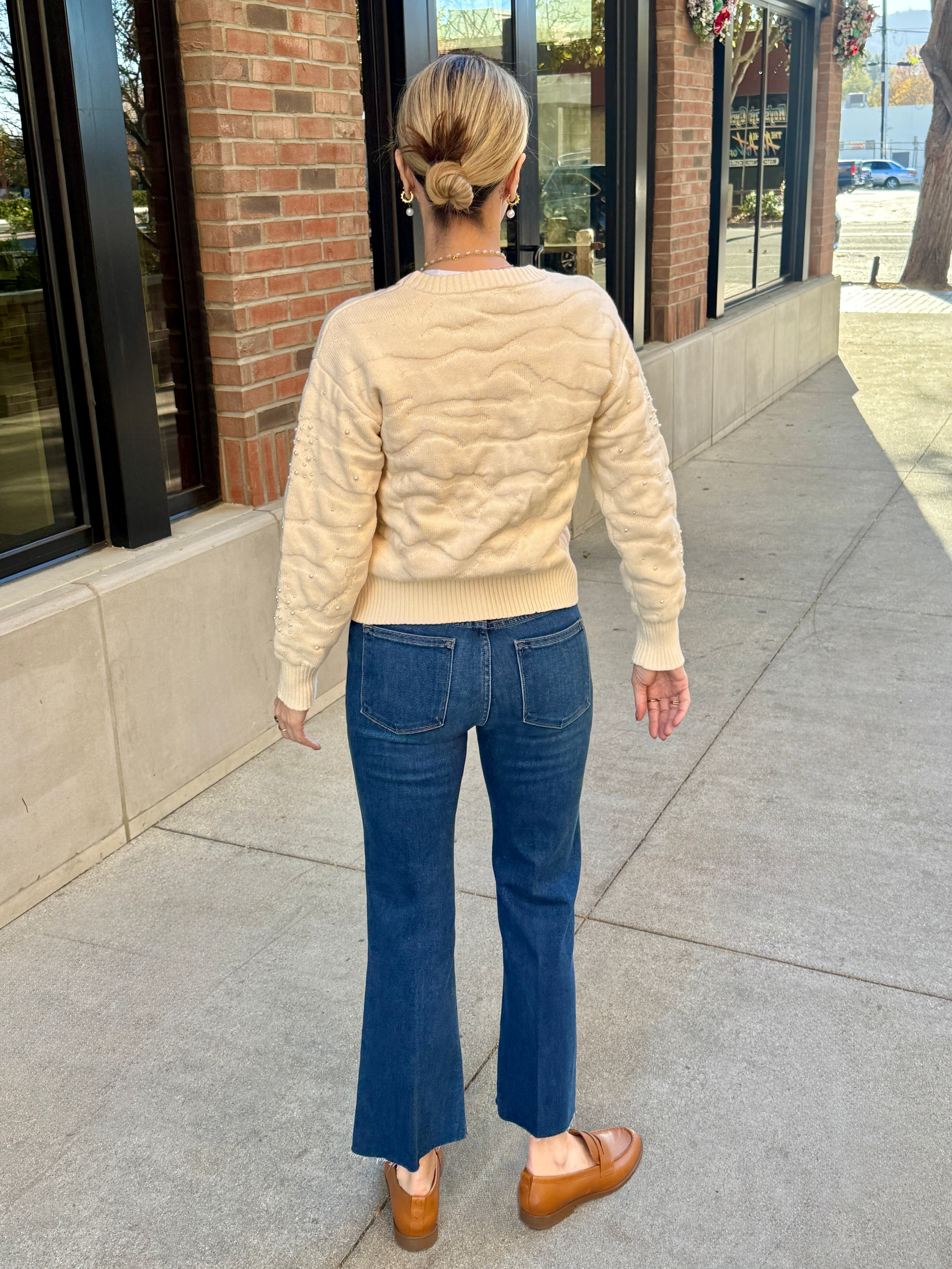 cream pearl detail winter sweater and blue jeans