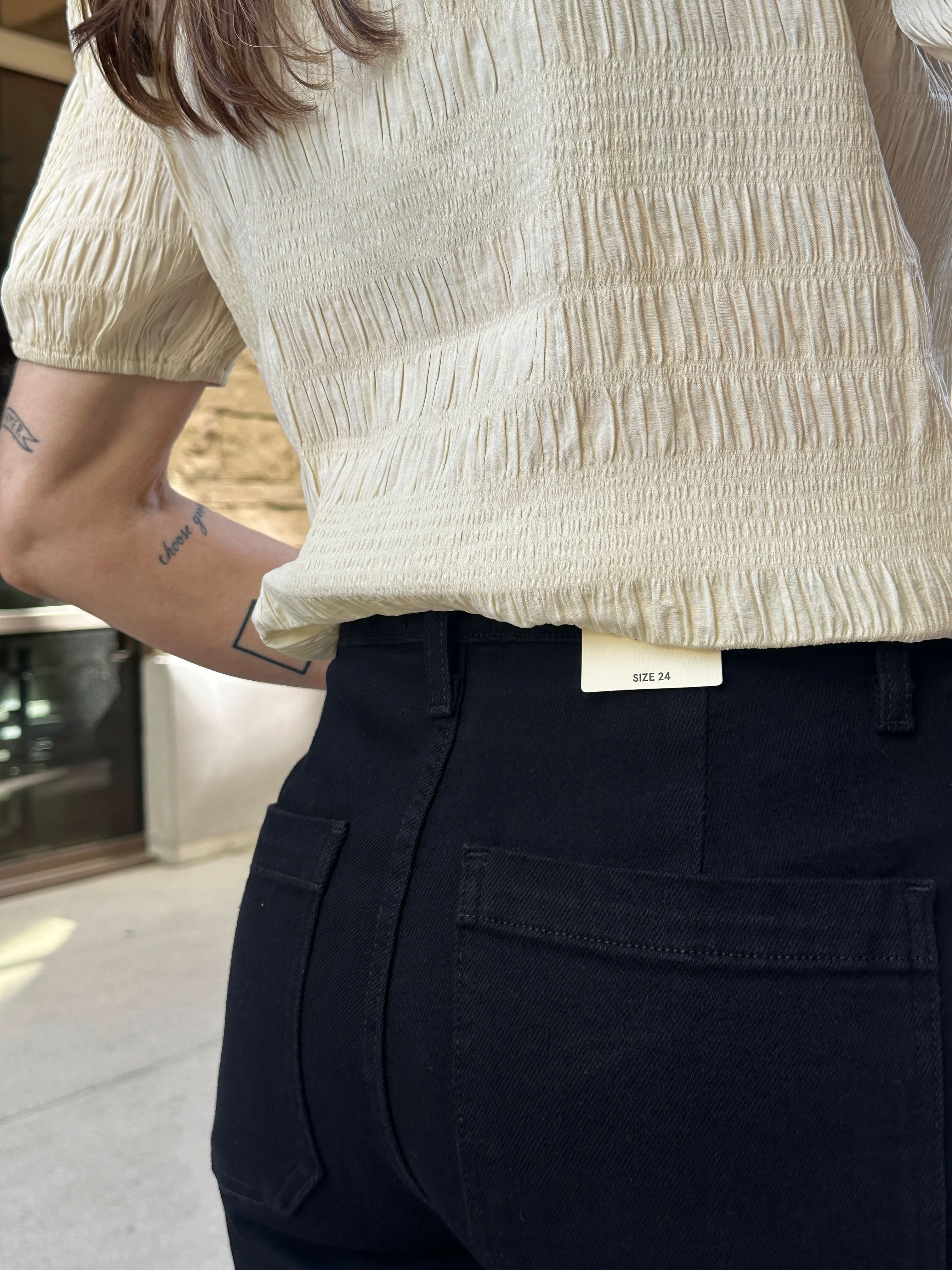 Close-up of a person wearing black Juliet Paris Jeans