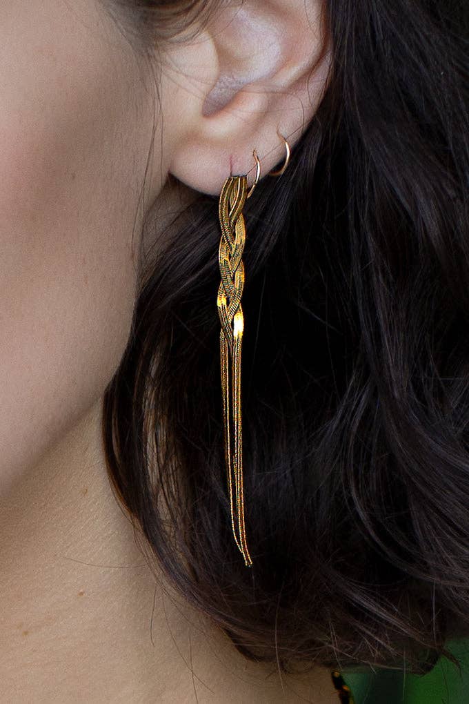 Gold earrings worn by a person with dark hair.