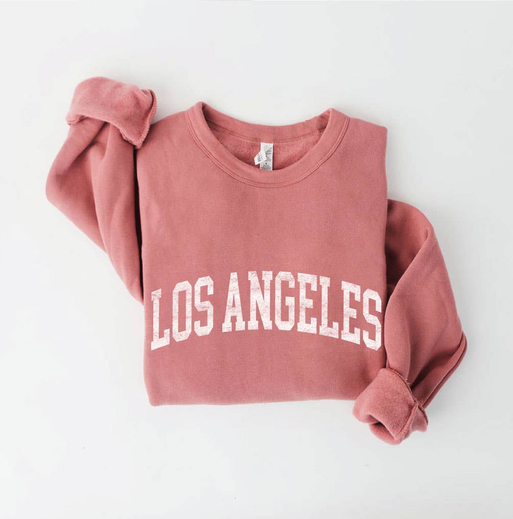 Los Angeles Sweatshirt in a folded, featuring the words "LOS ANGELES" printed in large white capital letters.