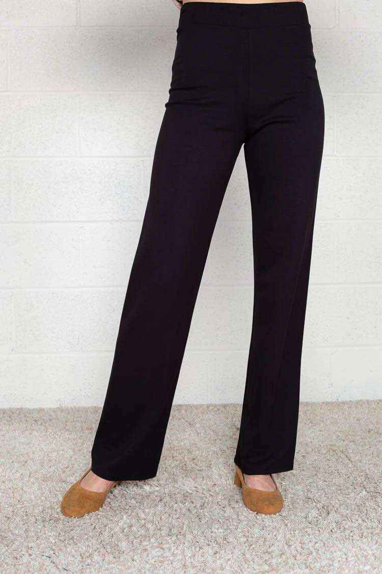 Woman wearing flats and black Micah pants that are skinny on the top with wide bottom
