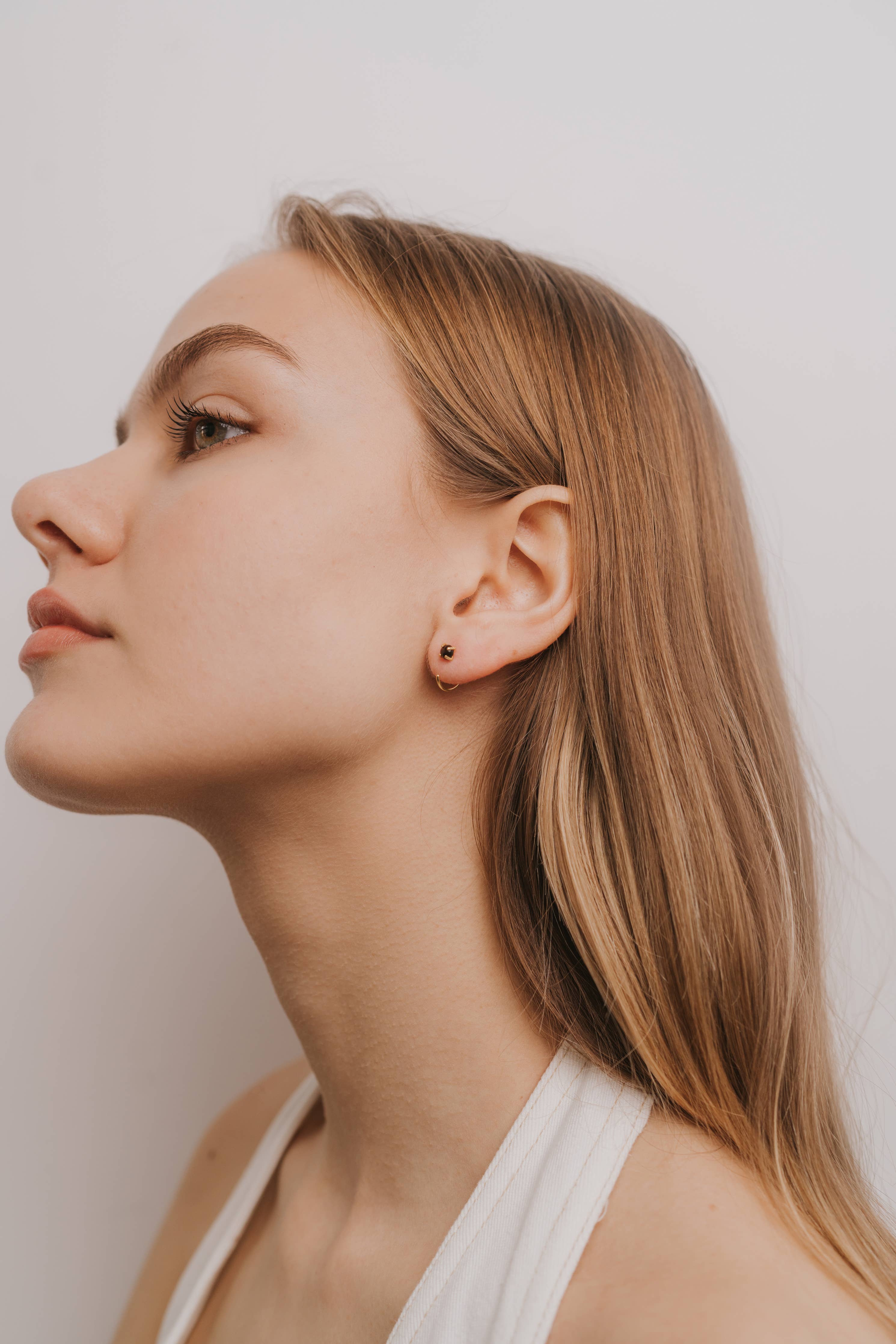 Close-up of a woman's face with a neutral expression against a plain background