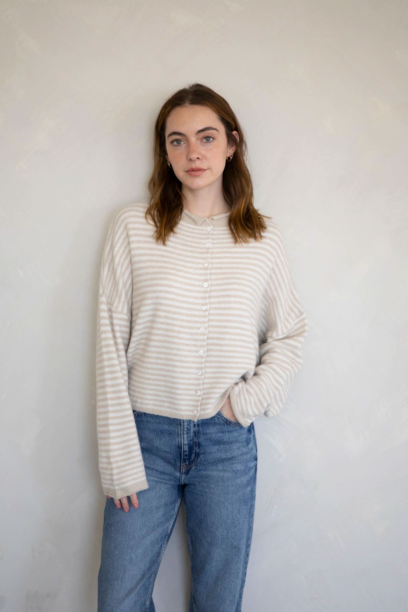 Woman wearing a white and cream color striped sweater 