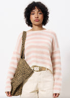 woman wearing cropped long sleeve sweater with pink and white stripes