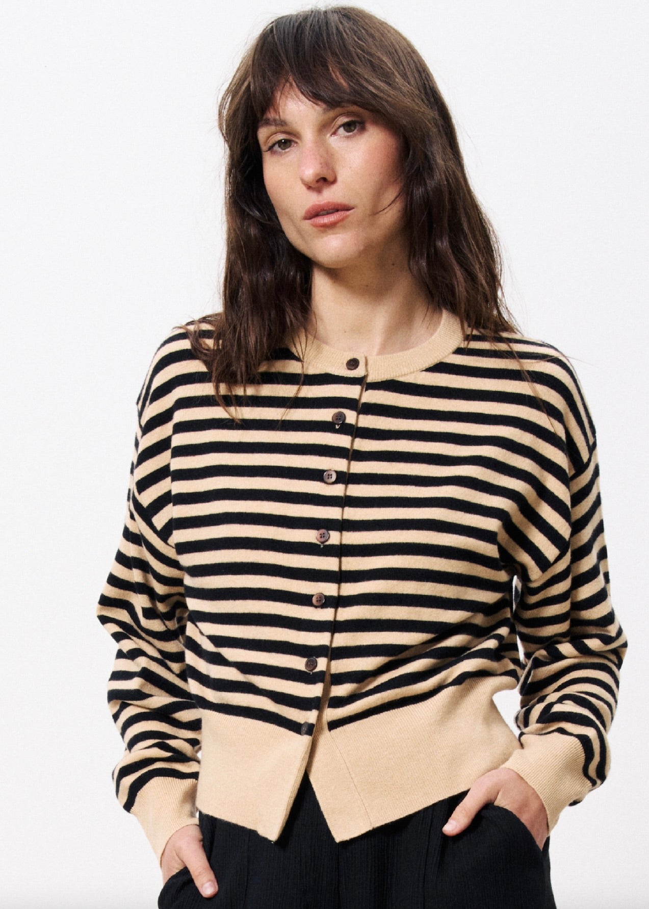 woman wearing long sleeve cardigan with brown and black stripes with black buttons