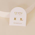 Gold zodiac charm studs in the shape of Gemini astrological sign displayed on earring card