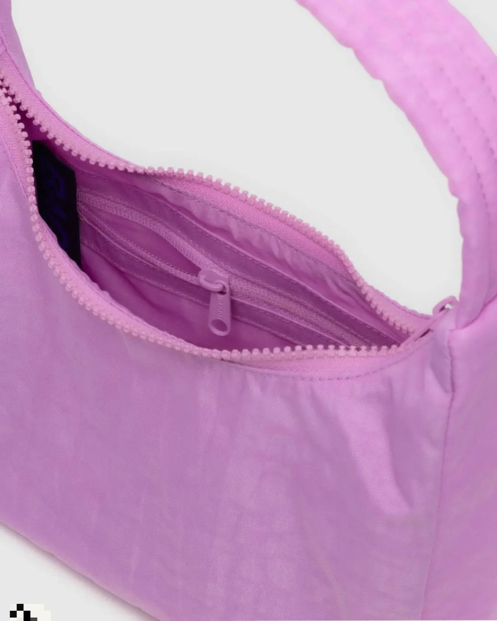 inside details of pink peony colored nylon baggu shoulder bag on white background wearing