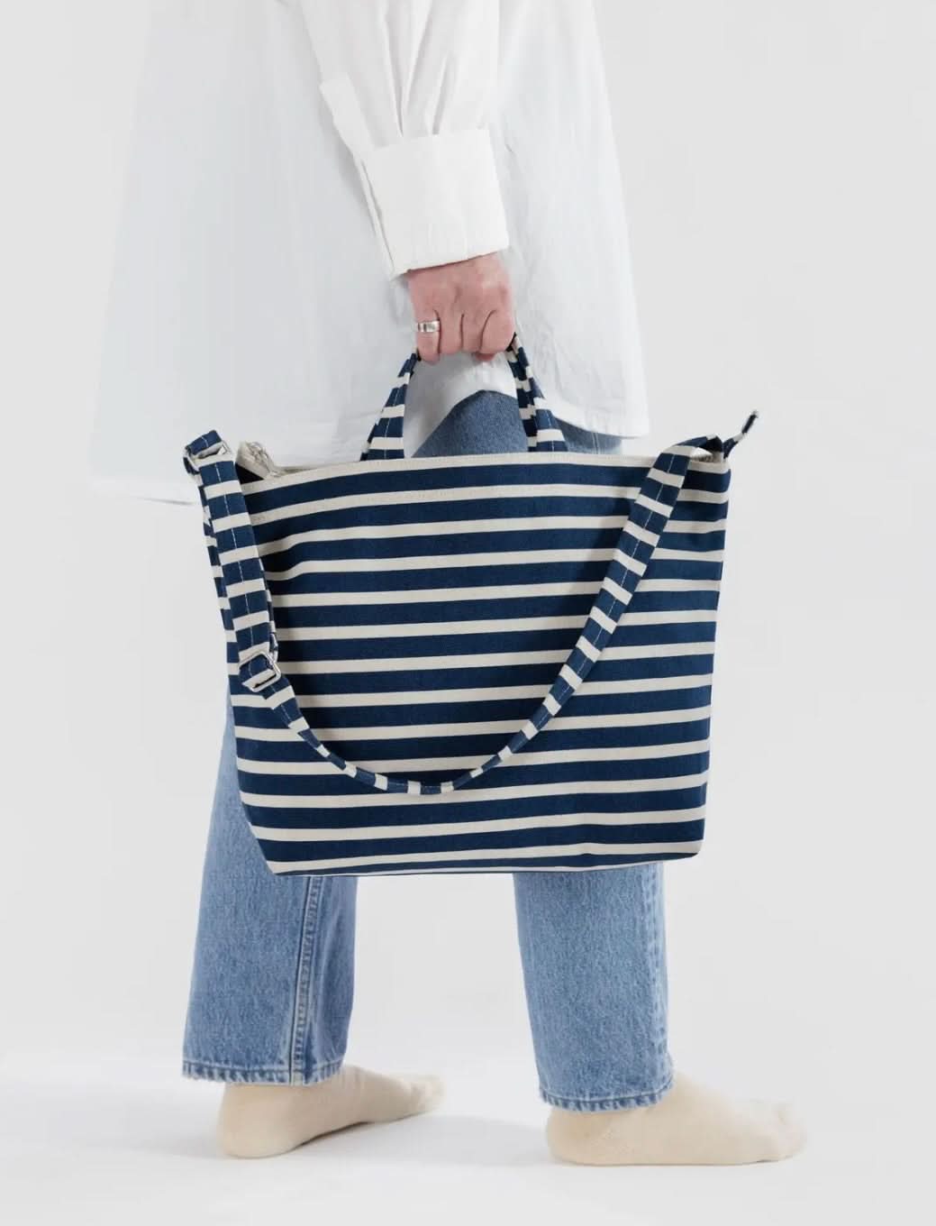 Woman carryingBlue and white horizontal duck bag from BAGGU 