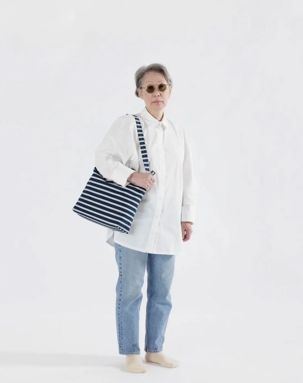 Woman carryingBlue and white horizontal duck bag from BAGGU 