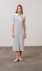 Woman wearing black and white striped midi sweater dress with white collar 