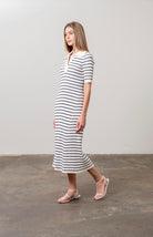 Woman wearing black and white striped midi sweater dress with white collar and short sleeves 