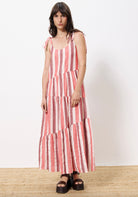 Woman wearing red, burgundy and white griped liner dress straps tied at shoulder 