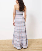 Woman wearing long red white and blue striped strapless dress, smocked on the chest