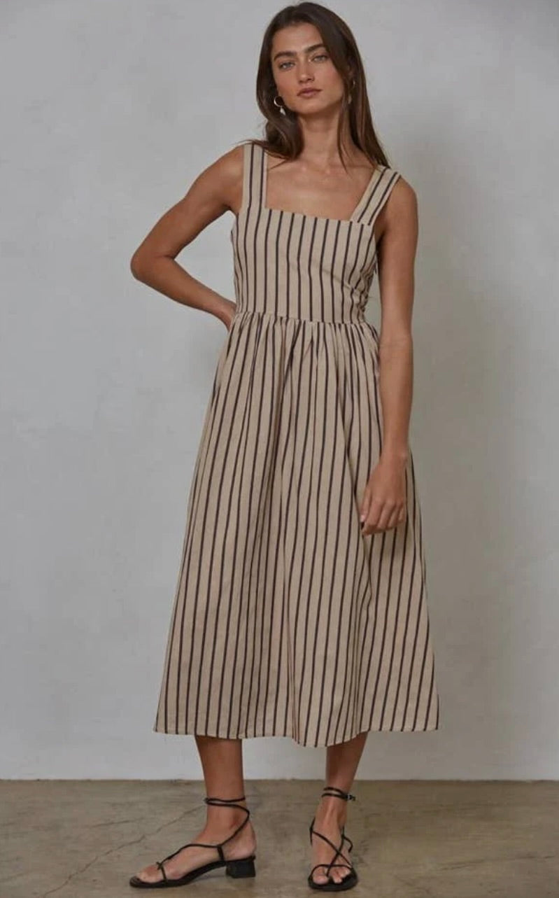 Woman wearing latte brown colored midi dress with vertical blue/black and red striped 