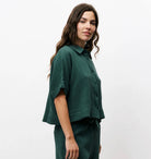 Woman wearing matching dark Forrest green, shorts and short-sleeve set